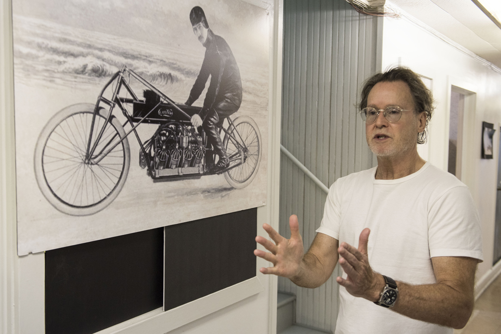 Curtiss CEO Matt Chambers in front of a depiction of Glenn H. Curtiss at Ormond Beach, FL, where he rode his 40 bhp, 4410cc V8-powered motorcycle to a World Land Speed Record of 136.36 mph in January 1907.