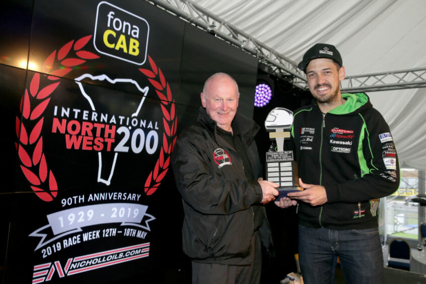 James Hillier (Quattro Plant Kawasaki) receives the Robert Dunlop Man of the Meeting award from fonaCAB International North West 200 in association with Nicholl Oils Event Director, Mervyn Whyte, after his 1st, 2nd and 3rd place finishes at this year's 90th anniversary races.