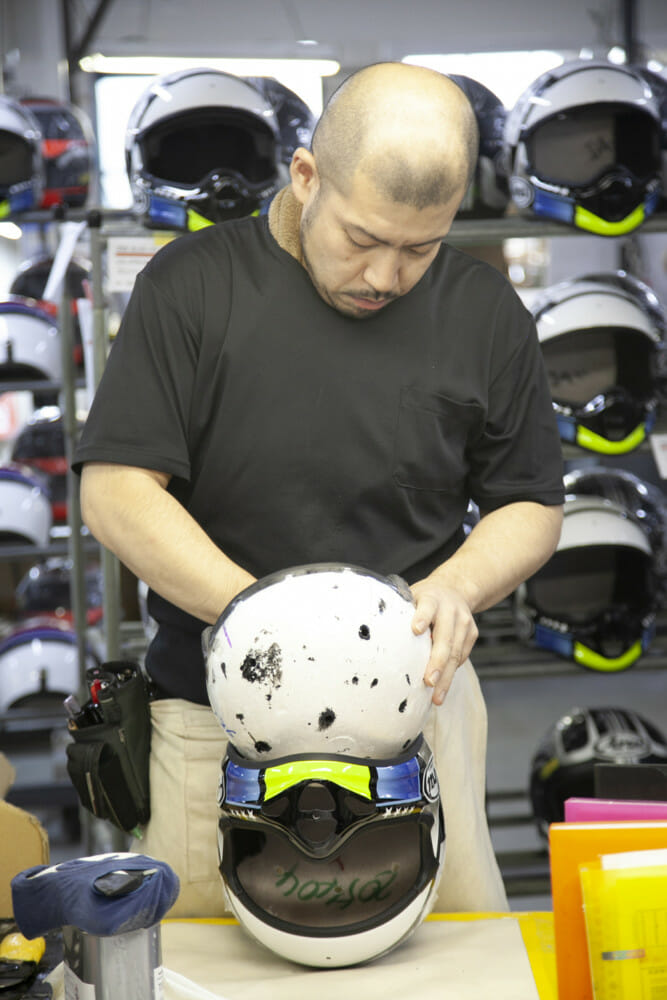 An EPS liner technician working on an Arai helmet.